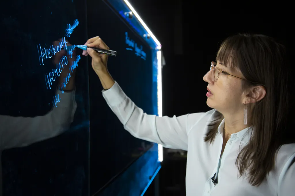 A professor stands in front of a light board.
